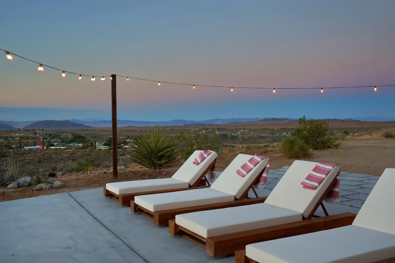 Living room at dusk with the pool glowing