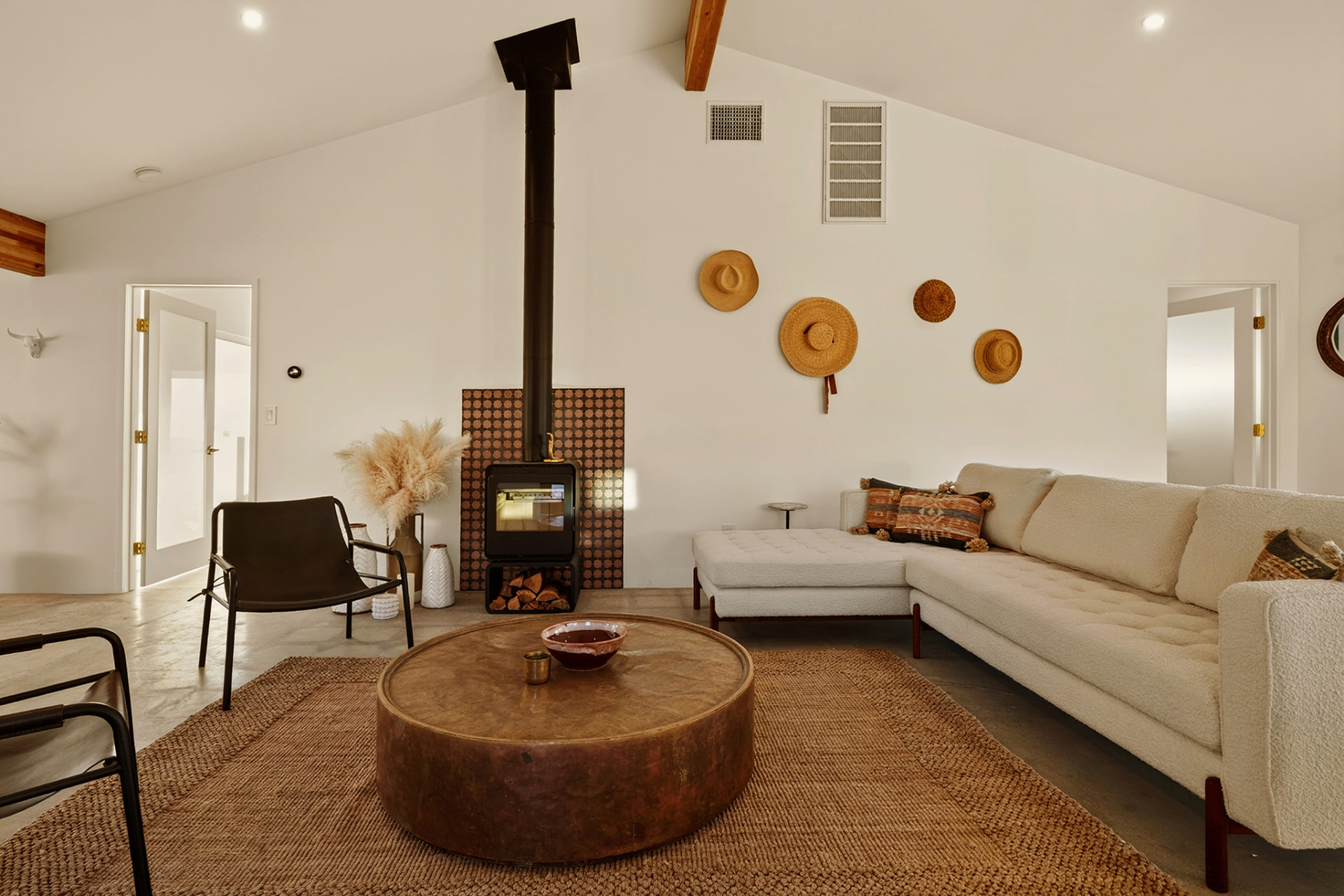 Living lounge with copper table, sectional and hat wall