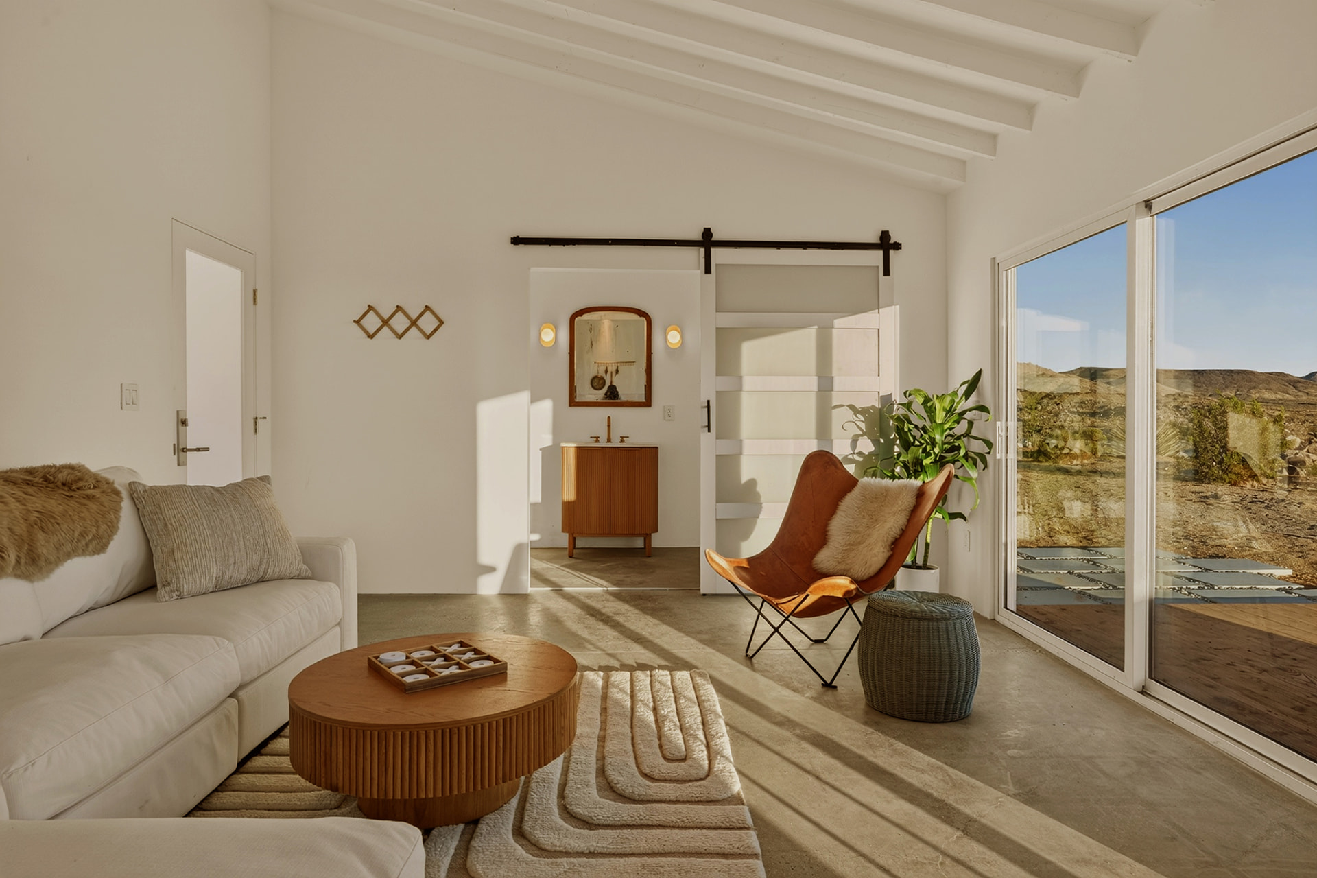 Casita living room with butterfly chair and barn door en suite